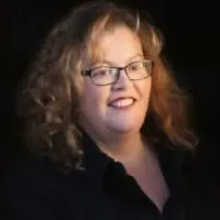 Smiling woman with glasses and curly hair