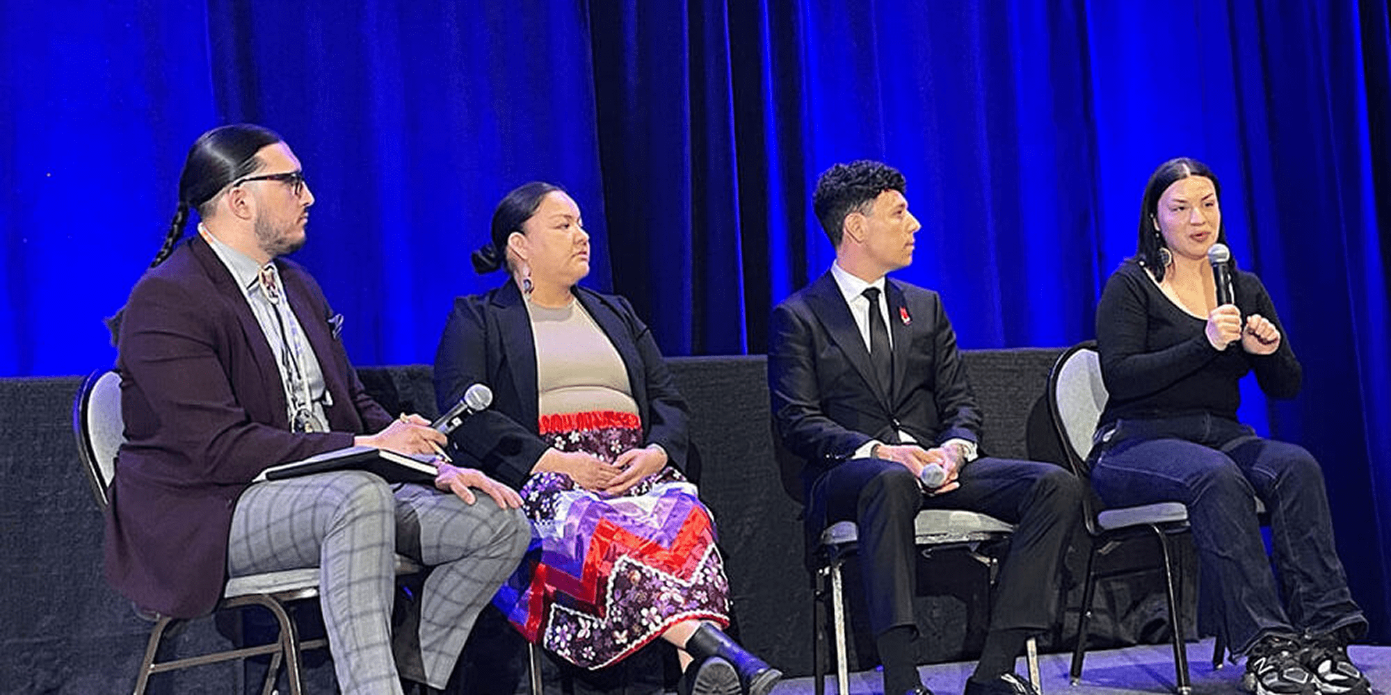 Four people speaking at a conference event.