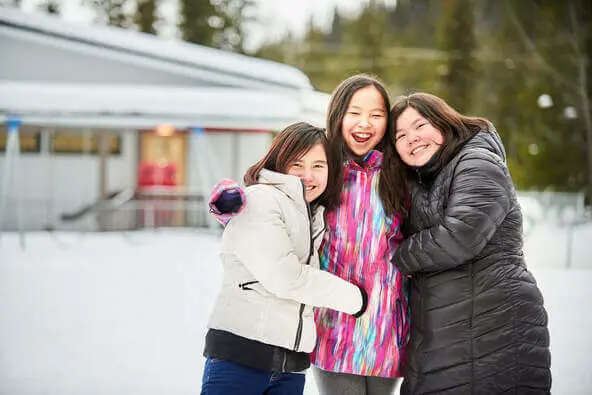 Three people enjoying snowy day