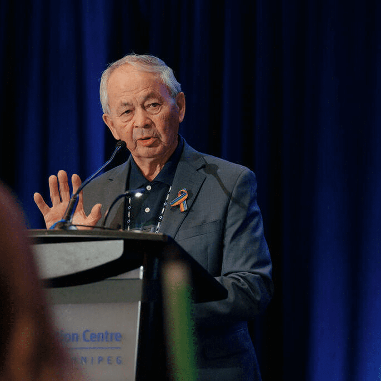 Elderly man speaking at a podium