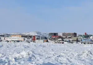 Snow-covered cityscape with distant buildings