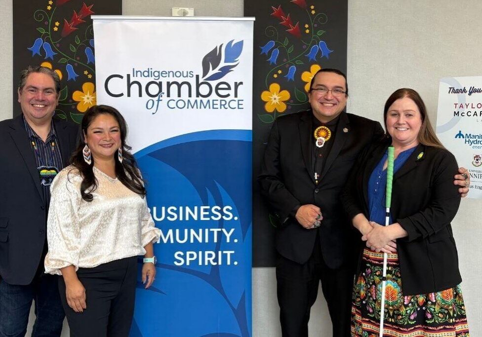 People standing beside chamber banner