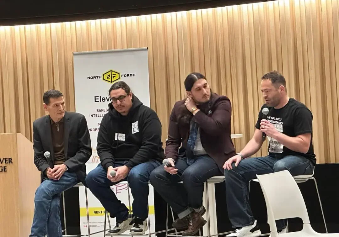 Panel discussion with four men on stage