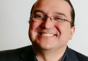 Smiling man with glasses and suit