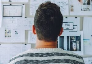 Person viewing brainstorming wall with pinned notes