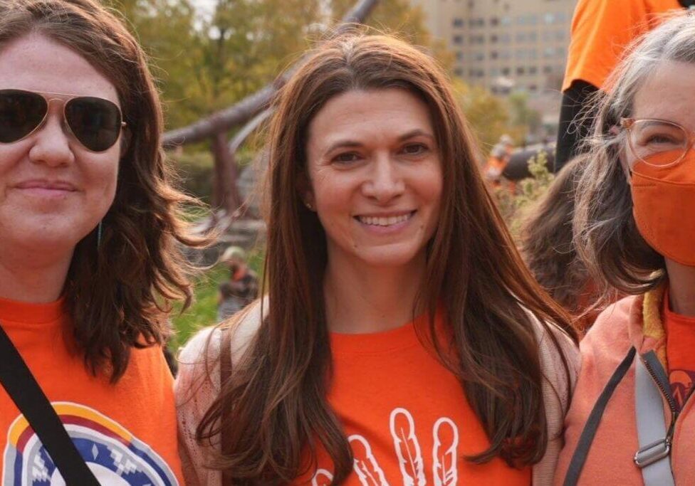 Three people wearing orange shirts